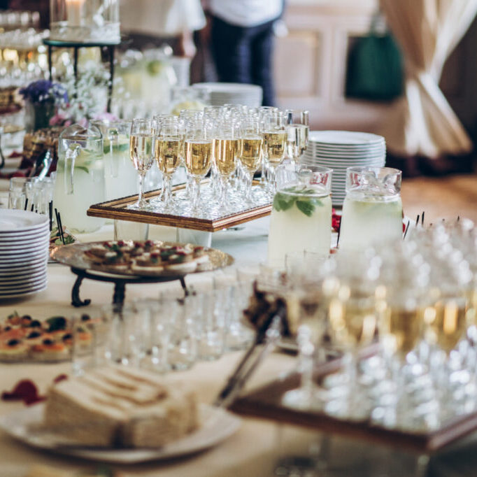 stylish champagne glasses and food  appetizers on table at wedding reception. luxury catering at celebrations. serving food and drinks at events concept